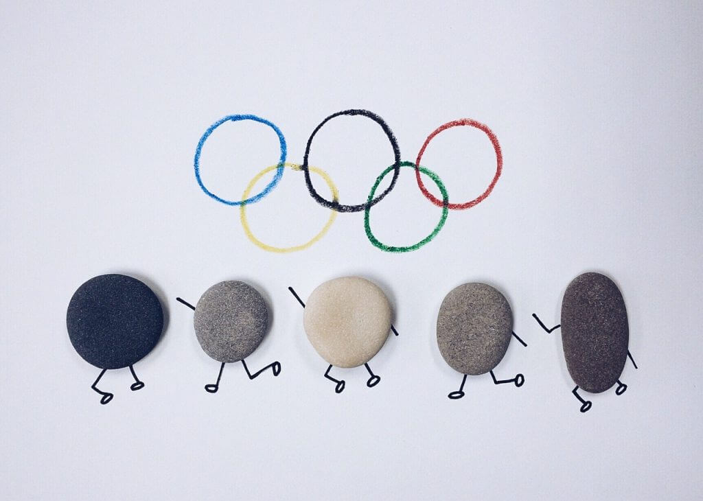 Anneaux olympiques et athlètes représentés par des cailloux