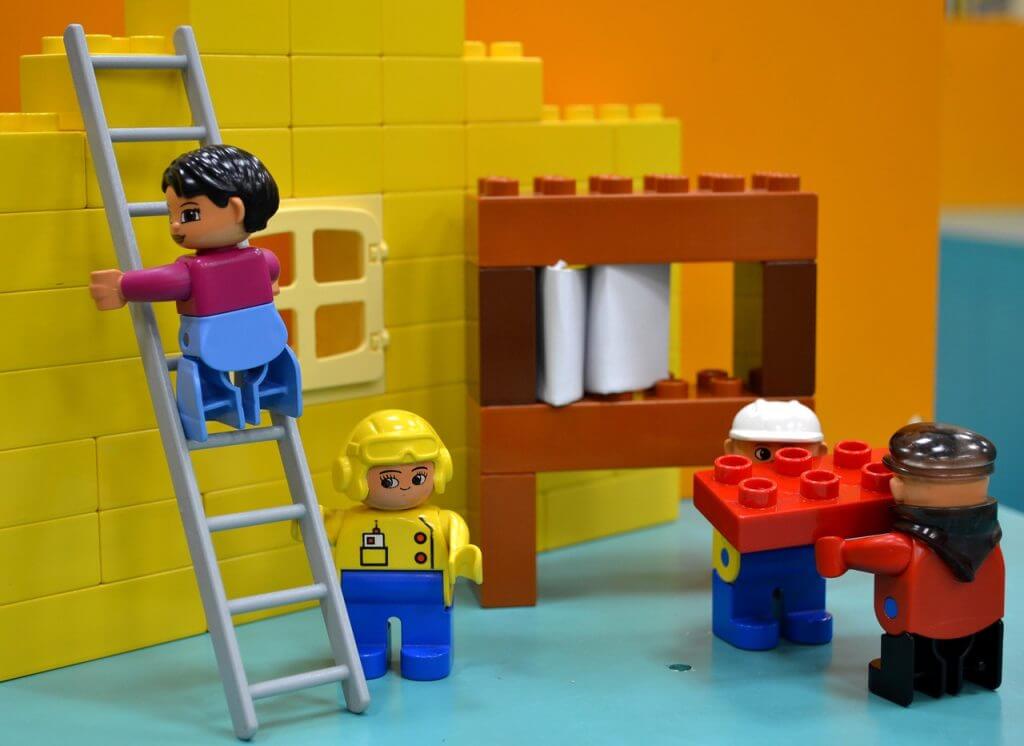 Personnages Lego construisant une maison